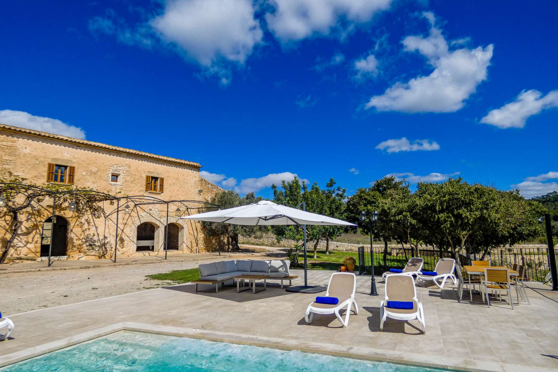 Fachada histórica, piscina y terraza de Son Pons preparadas para recibir a los huéspedes